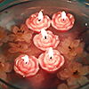 flower shaped candles lit in water