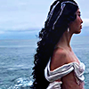 a person facing the side against an ocean