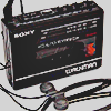 a black sony cassette walkman with earbuds attached