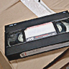 one black VHS tape on a cardboard box