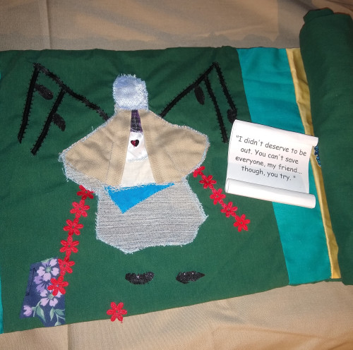 panel 2 applique angel pieced of all the types of clothing Cas wore on his vessel with featherless wings, a few black feathers raining down, two lines of red flowers resembling blood flow from the angels hands. scroll with words, I didn't deserve to be out. You can't save everyone my friend... though you try.