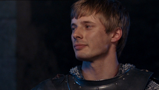 a shot of Arthur in the round table episode looking down at Merlin with a small smile looking pleased.