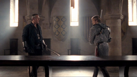 a side shot of Arthur and Uther facing off with swords after Arthur confronts Uther about being at fault for the death of Ygraine