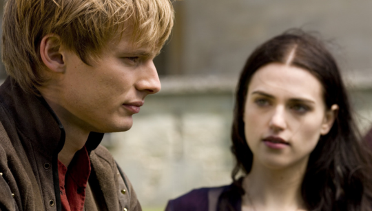 a sideview of Arthur staring off of the battlements and a slightly blurry front facing view of Morgana looking at him