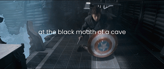 a gif of Bucky in the alps on the train with the door open behind him standing up while shooting a gun and holding Steves shield and the text on the gif reads at the black mouth of the cave.