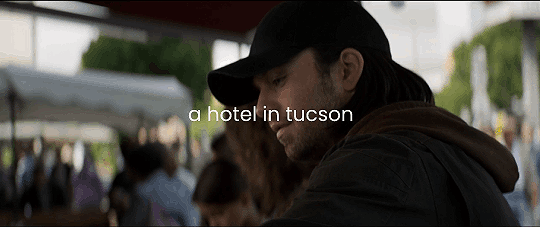 a gif of a side shot of Bucky as he smiles a little and buys plums and the text on the gif reads a hotel in tucson.