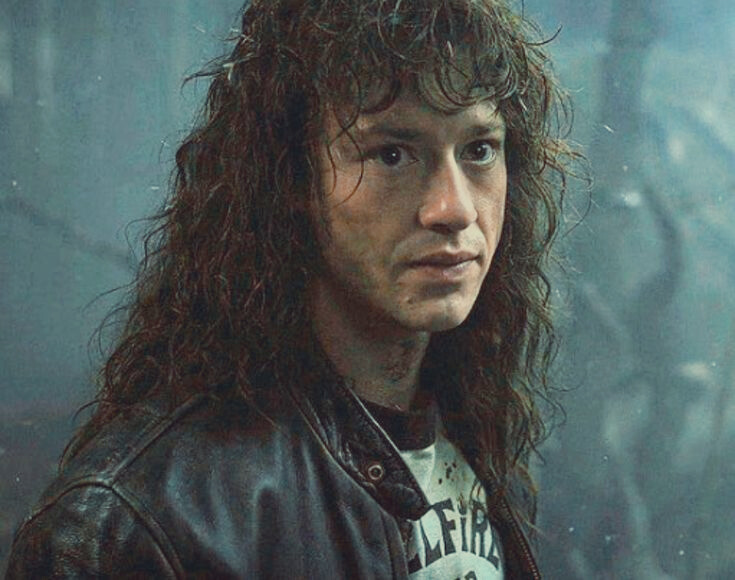 a picture of Eddie in the upside down with messy hair looking incredibly serious as he stares at Steve after throwing his vest at him.