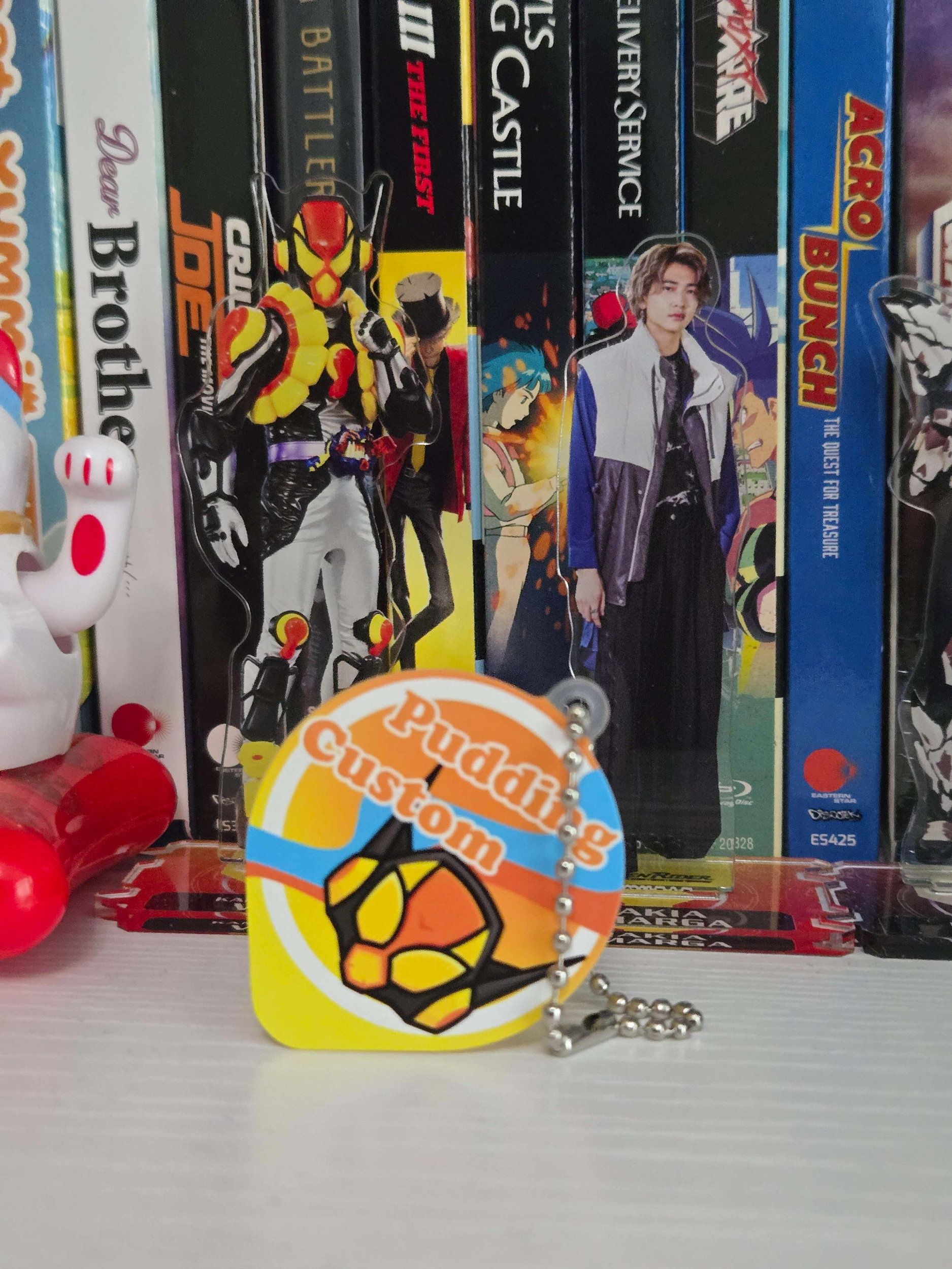 Lakia and Vram standees behind the pudding custom charm.