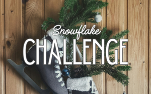 Snowflake Challenge: A pair of ice skates hanging on a wood paneled wall. Pine boughs with a few ornaments are stuffed into the skates.