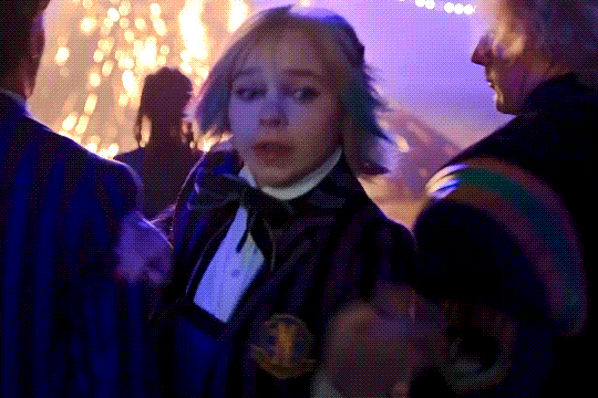 Enid escaping through a crowd.