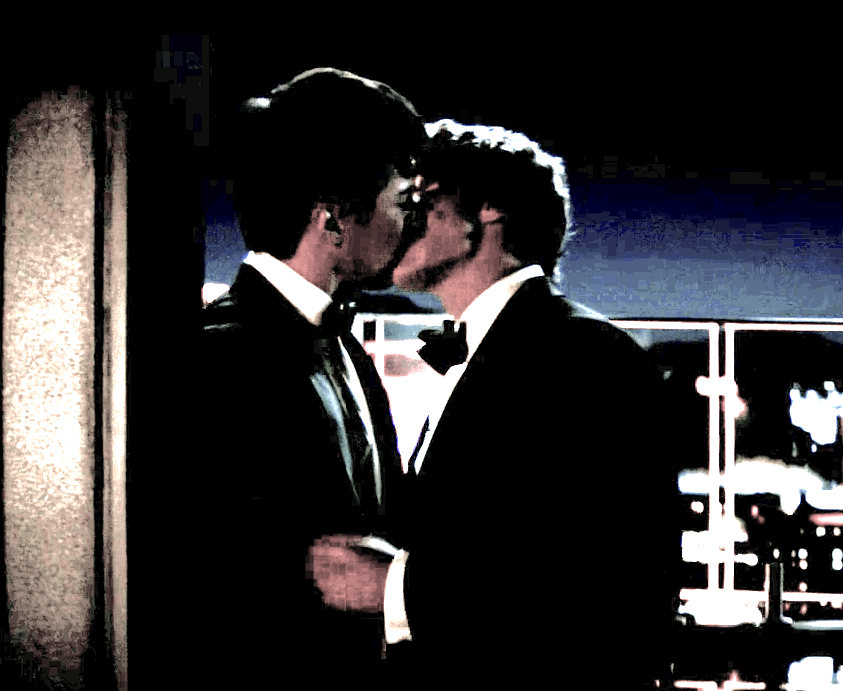 grainy image of two people kissing on a rooftop (they look like shane and ilya)