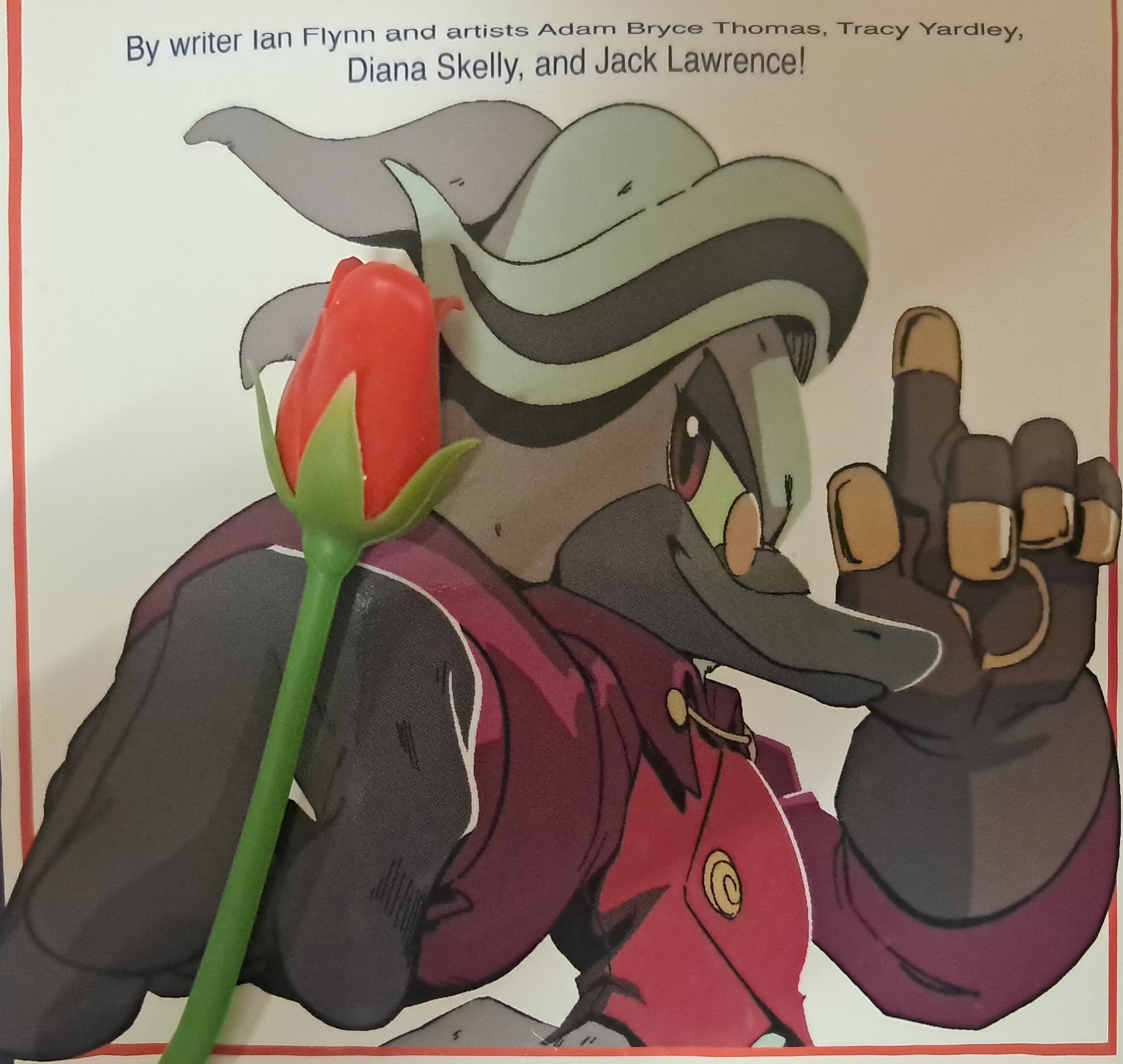 Photo of a panel where Starline has his hand extended towards the viewer. I placed a rose-shaped bookmark on his hand, making it look like he is holding a rose.