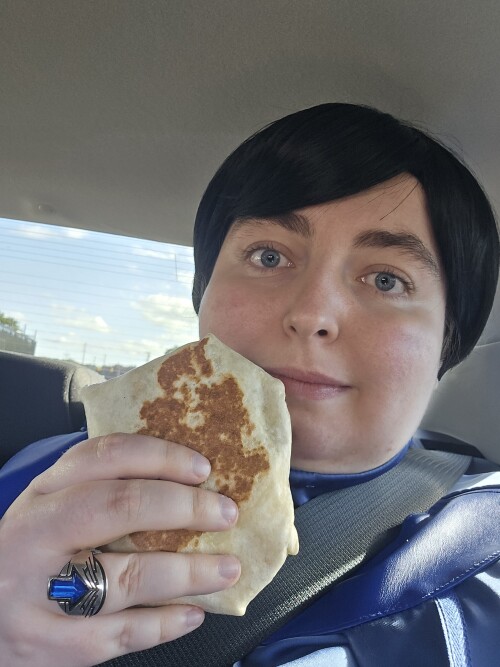 Me in cosplay holding a breakfast crunchwrap.