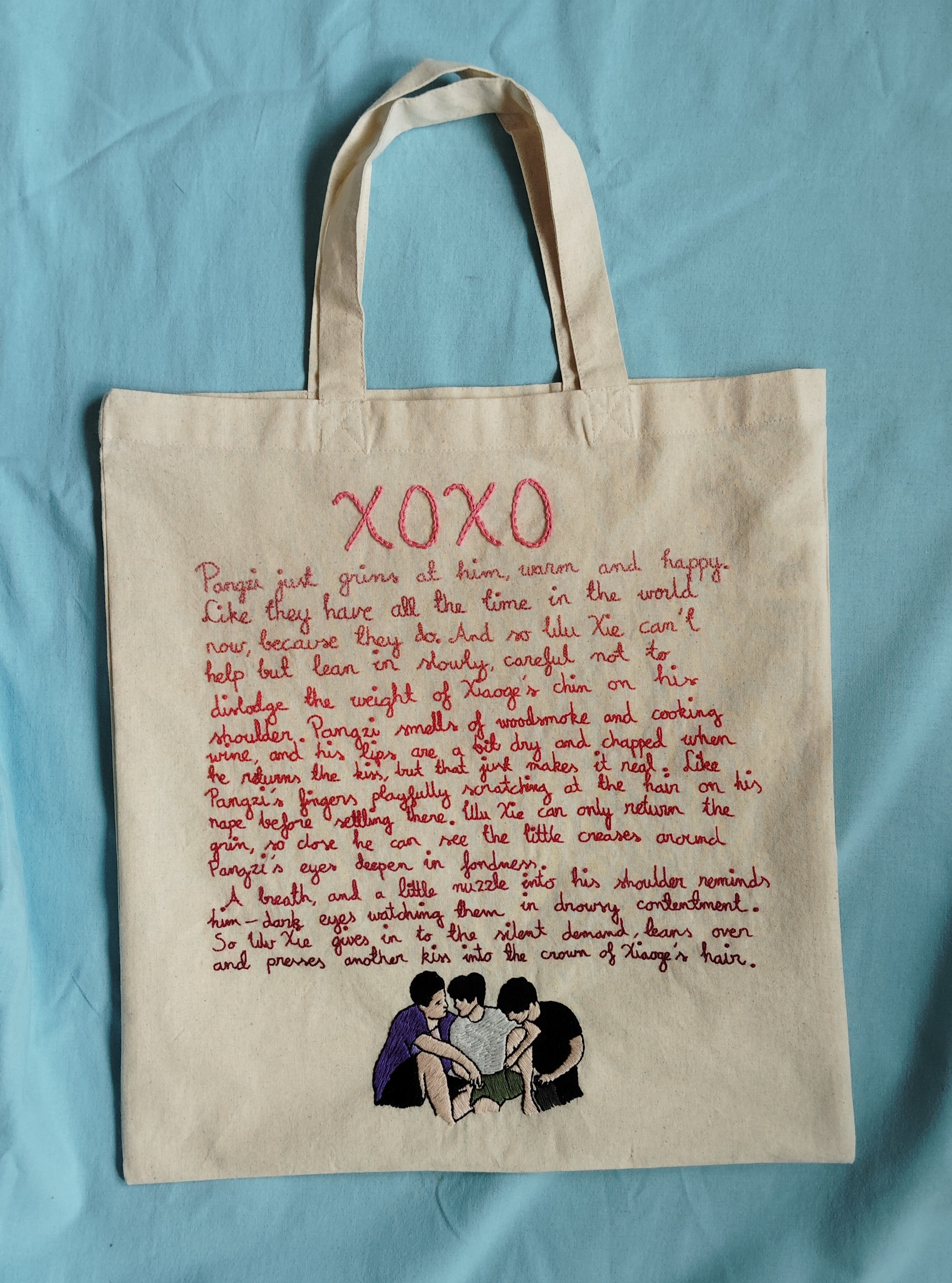 Embroidered tote bag, with the full text of the fic by cayra and an image of the iron triangle.