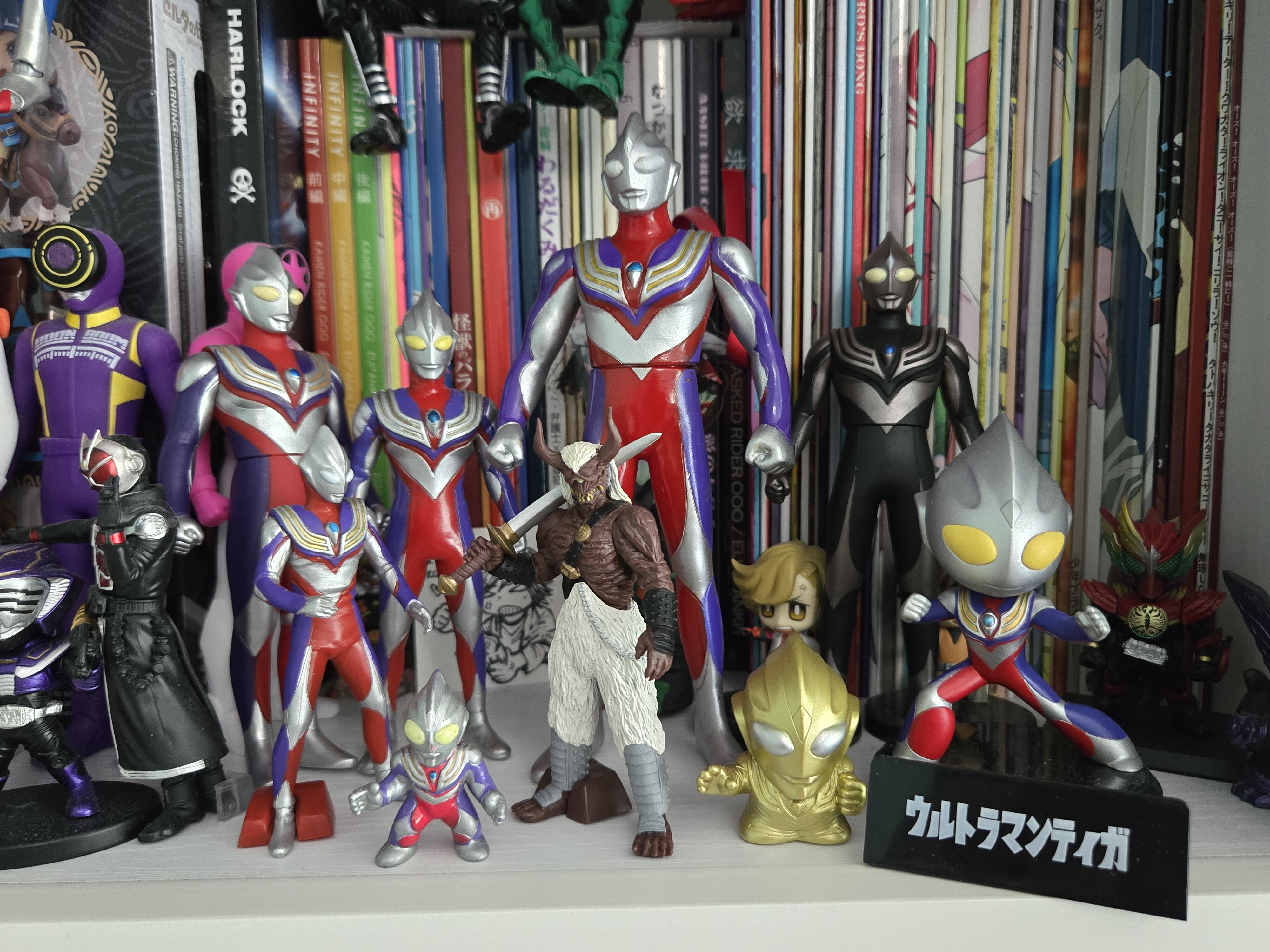 Multiple Ultraman Tiga figures on a shelf.